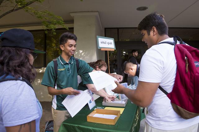 Orientation help table with students distributing orientation matterial